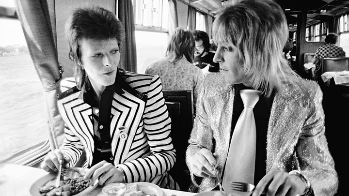 David Bowie and Mick Ronson enjoy a British Rail lunch on the train from London to Aberdeen on May 14th, 1973.