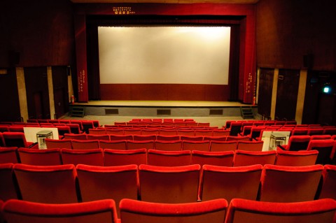 In Mumbai going for a movie is still a communal experience;  the  auditorium  is  packed, there are people to shush and the commentary is immediate. In the US... on an average movie night, it’s a few heads bobbing ominously  in  a  sea of  seats. Photo: Wikimedia commons