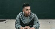 Jay Sean in a green jacket sitting with hands folded