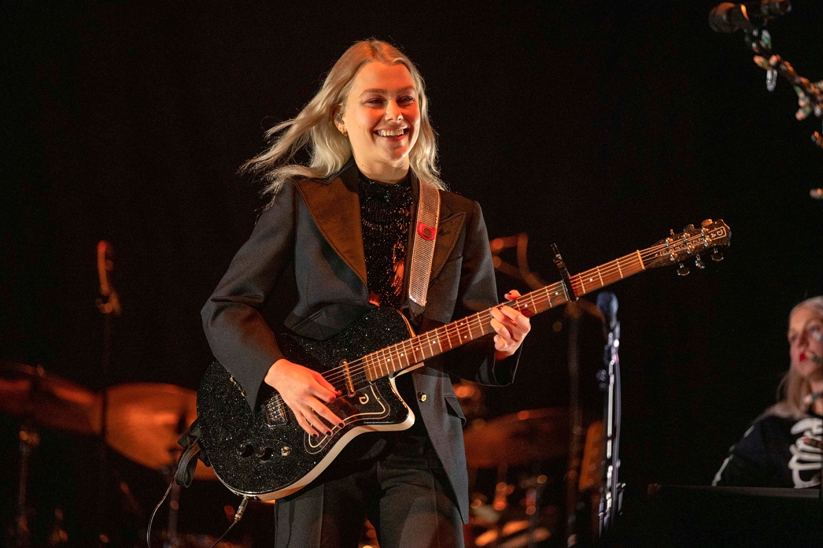 Phoebe Bridgers on stage playing guitar