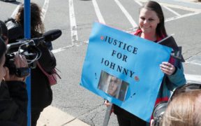 Supporter for Johnny Depp smiling and holding a blue placard