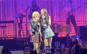 Avril Lavigne and Olivia Rodrigo wearing flannel plaid skirts and singing on stage