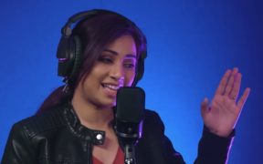 Shreya Ghoshal wearing headphones singing into mic