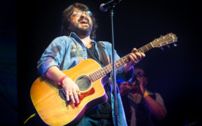 Pritam singing and playing acoustic guitar