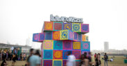 Attendees walk past a colorful installation with the Lollapalooza logo at Lollapalooza India music festival in Mumbai at Mahalaxmi Race course