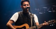 Hyderabad Telugu artist Shriram Alluri playing guitar on stage at concert