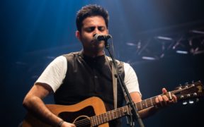 Hyderabad Telugu artist Shriram Alluri playing guitar on stage at concert