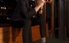 Amit Sial in a black suit sitting with hands folded