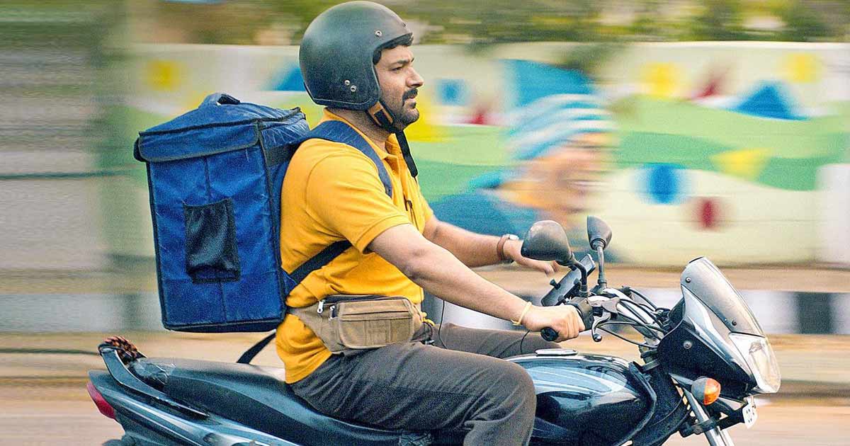 Kapil Sharma rides a motorbike in a still from the movie 'Zwigato'