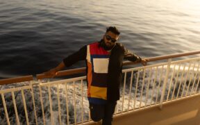 Kannada music artist All OK leaning on a rail on a ship cruise