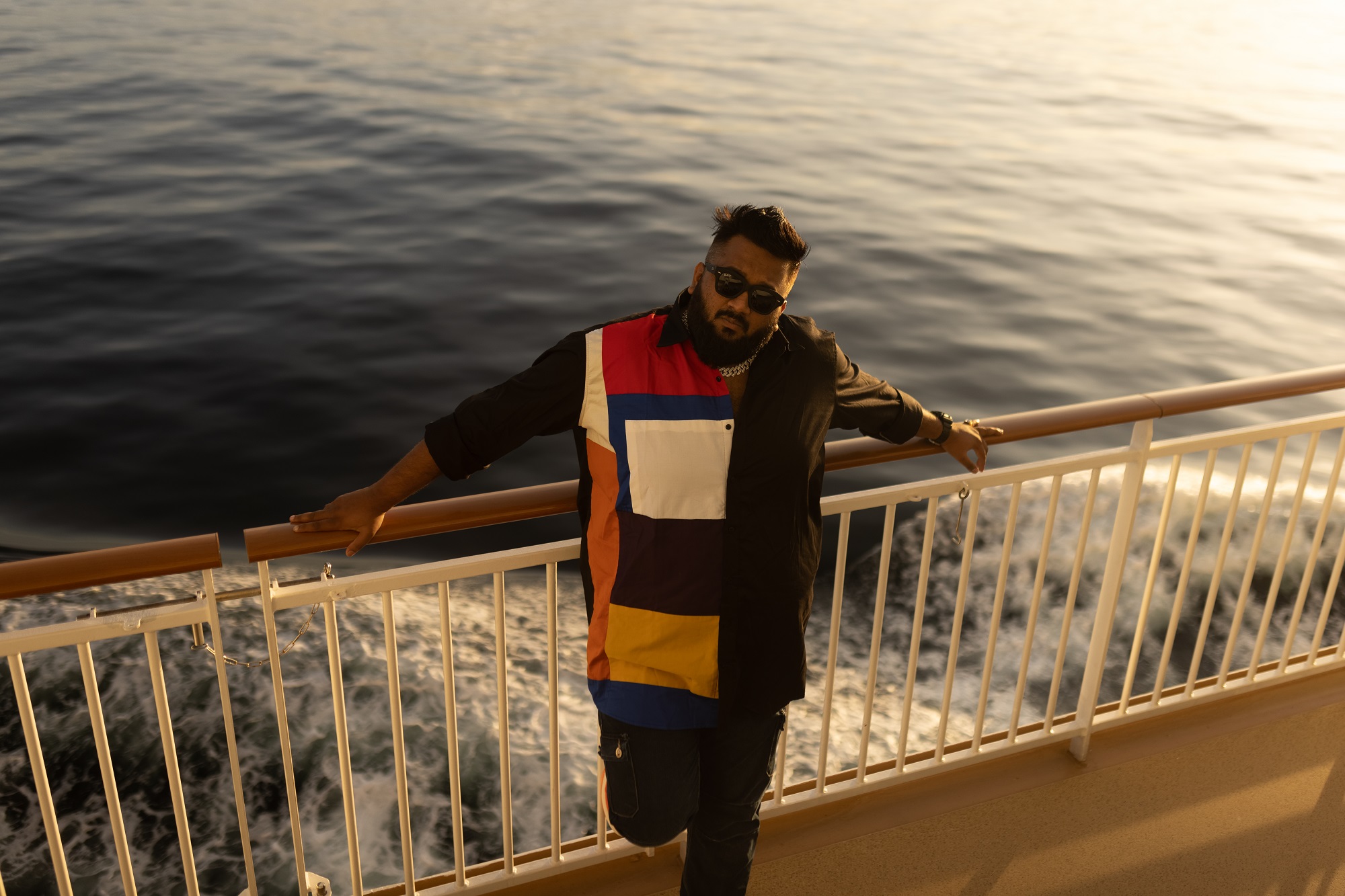 Kannada music artist All OK leaning on a rail on a ship cruise