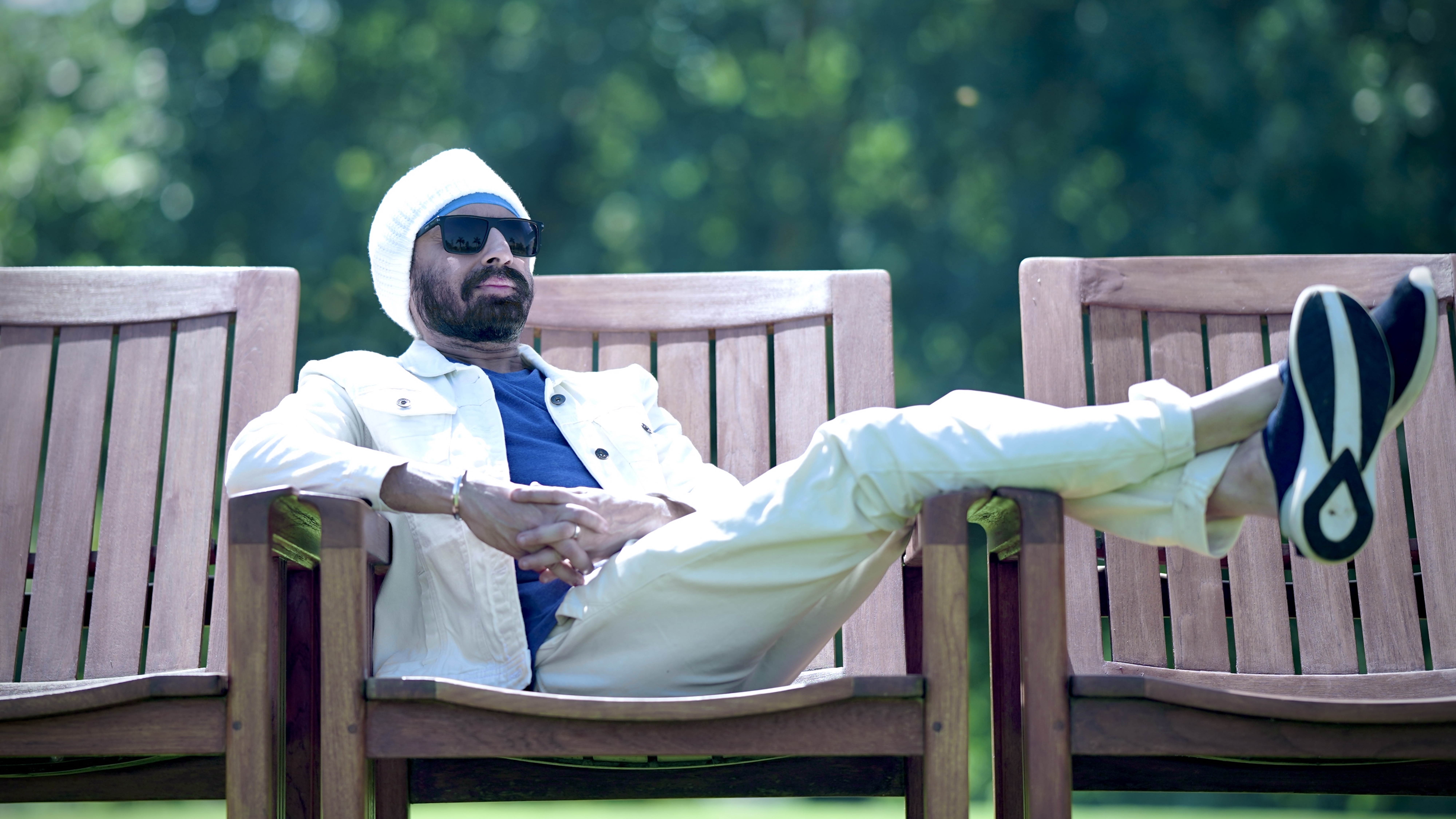 Vineet Singh Hukmani seated on a bench in a park in from his video for "Run! Run! Run!"