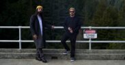 Rabab artist Qais Essar and sarod artist Alam Khan standing on a bridge