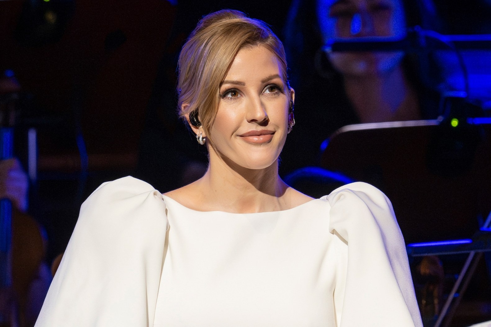 Ellie Goulding smiling wearing a white dress at an event in San Francisco