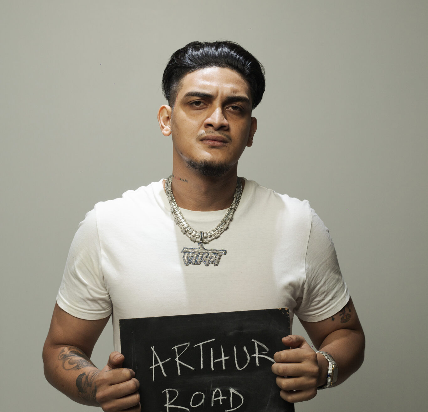 Rapper Loka holds a sign saying Arthur Road