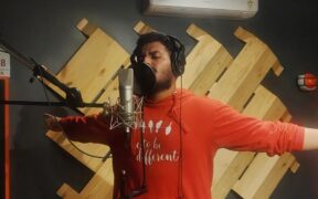Hyderabad rapper 2much aka Sushel Peraboina in the studio wearing a red t-shirt recording in front of a mic