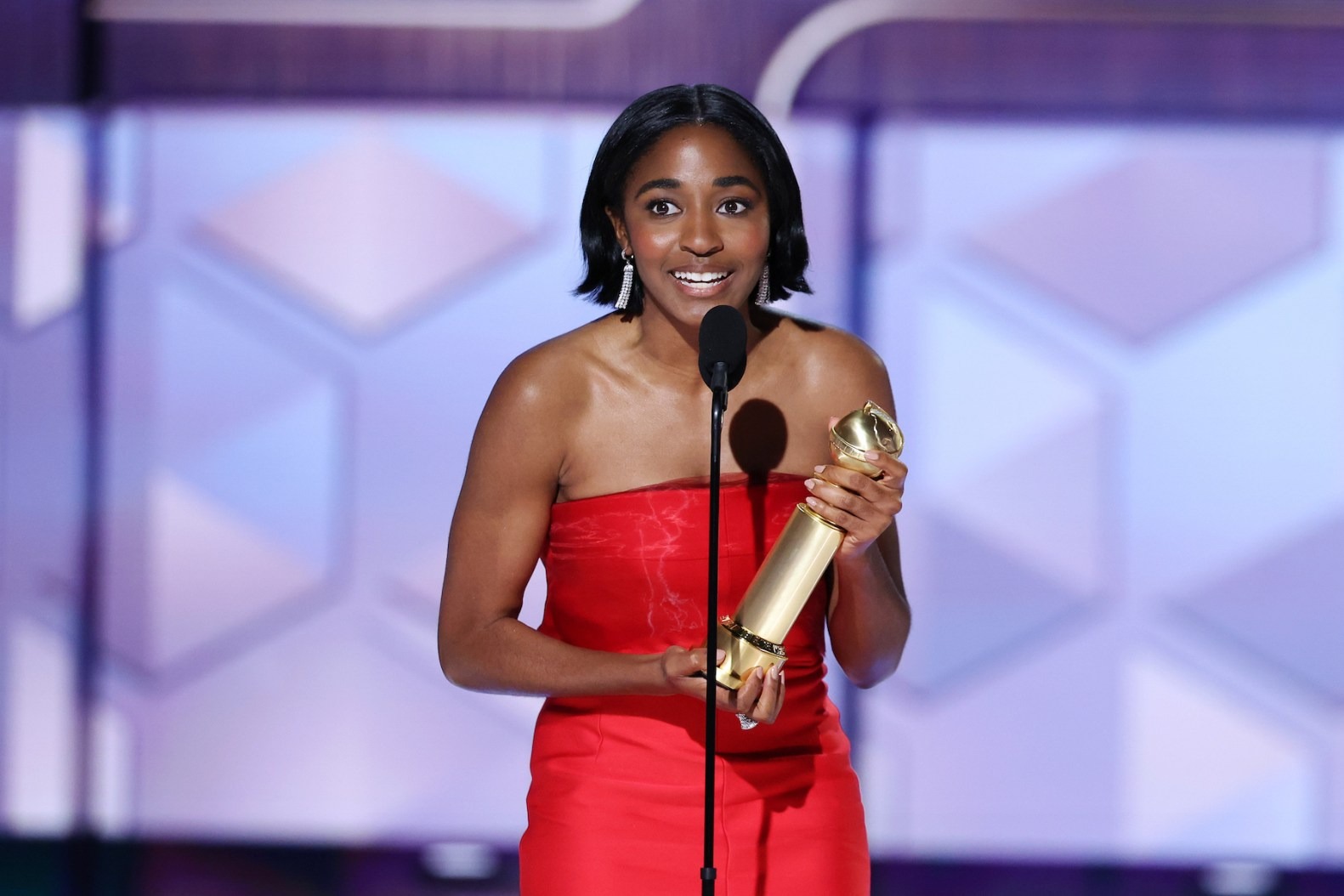 Ayo Edebiri in a red dress accepts Golden Globe award for The Bear