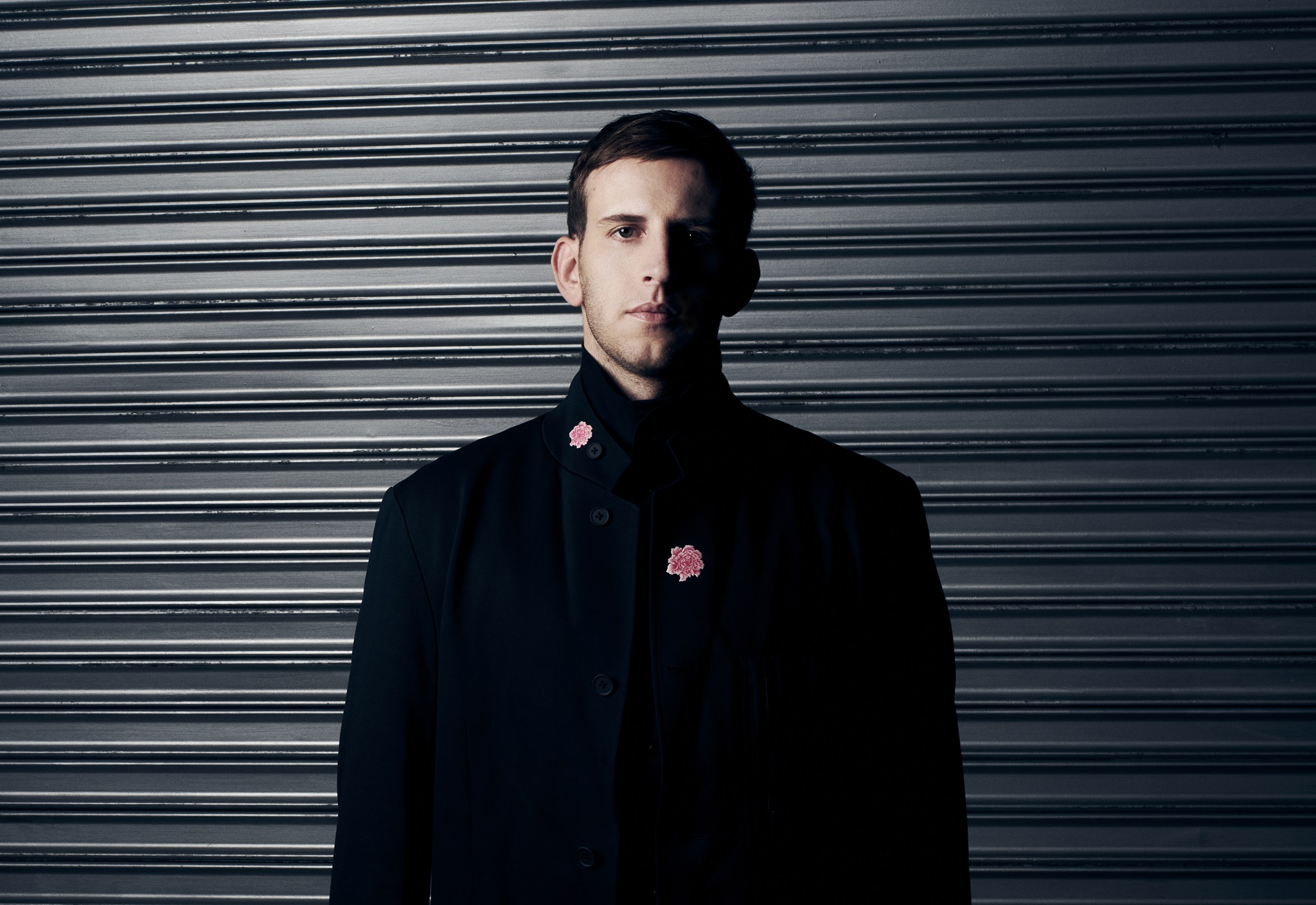 DJ and producer Illenium in a black suit looking at camera