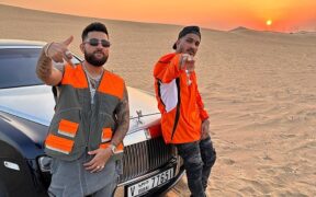 Karan Aujla and DIVINE standing by a car in the desert in Dubai