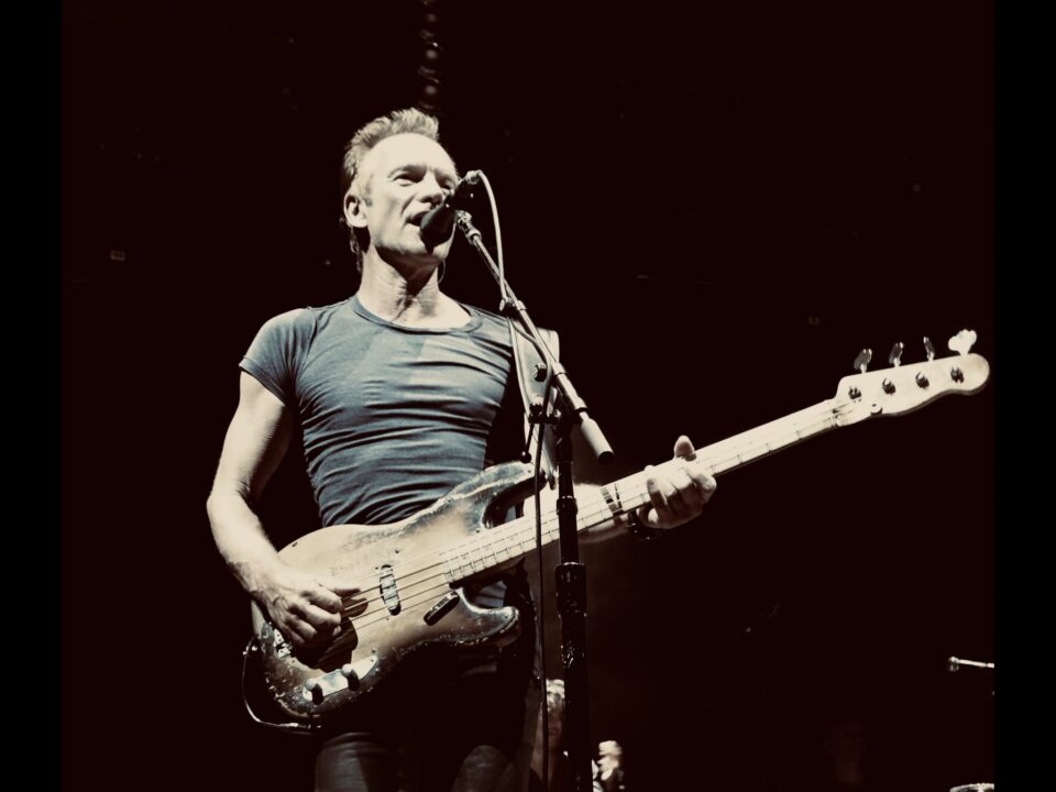 Sting playing bass and singing on stage