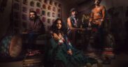 Band members of Surat rock act The Tapi Project pose for a photo in a dark room wearing colorful clothes