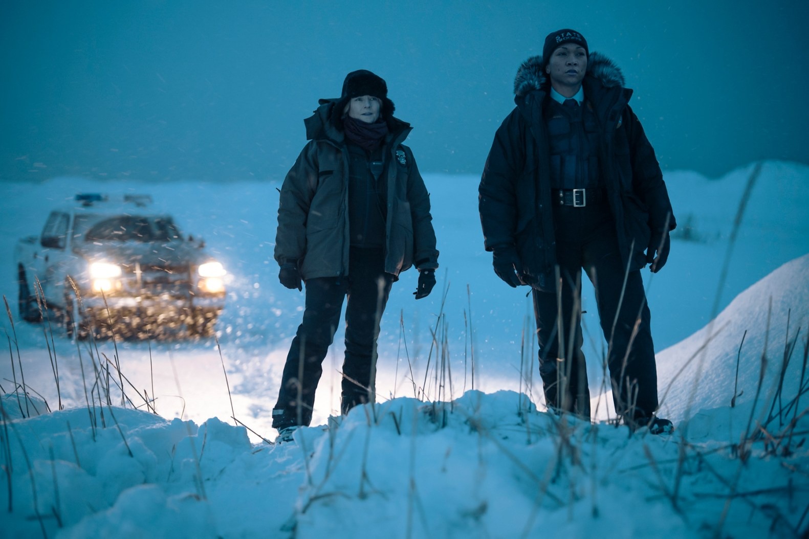 Jodie Foster and Kali Reis wearing jackets walking in the snow in a still from 'True Detective' Season 4