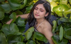 Music artist Swati Bhatt in a water body surrounded by leaves