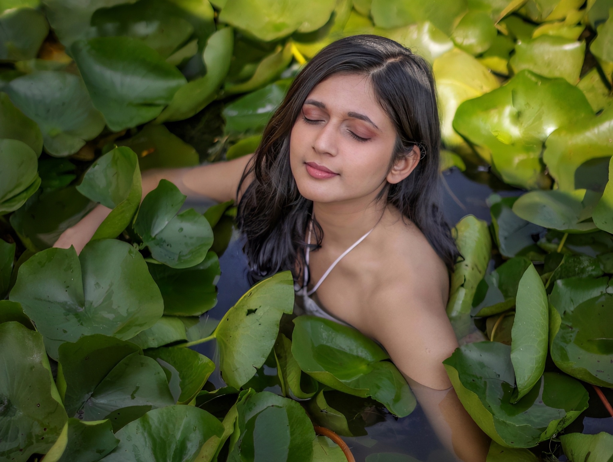 Music artist Swati Bhatt in a water body surrounded by leaves