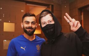 Virat Kohli smiling with DJ Alan Walker in black wearing mask