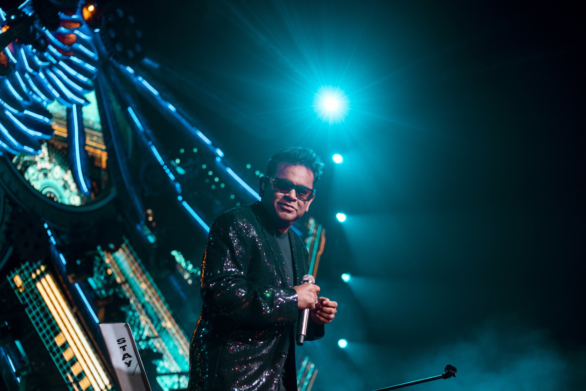 AR Rahman in a black suit wearing sunglasses on stage