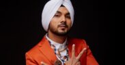 Singer Gurdeep Mehndi in an orange suit, raising his hands