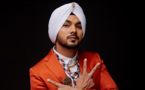 Singer Gurdeep Mehndi in an orange suit, raising his hands