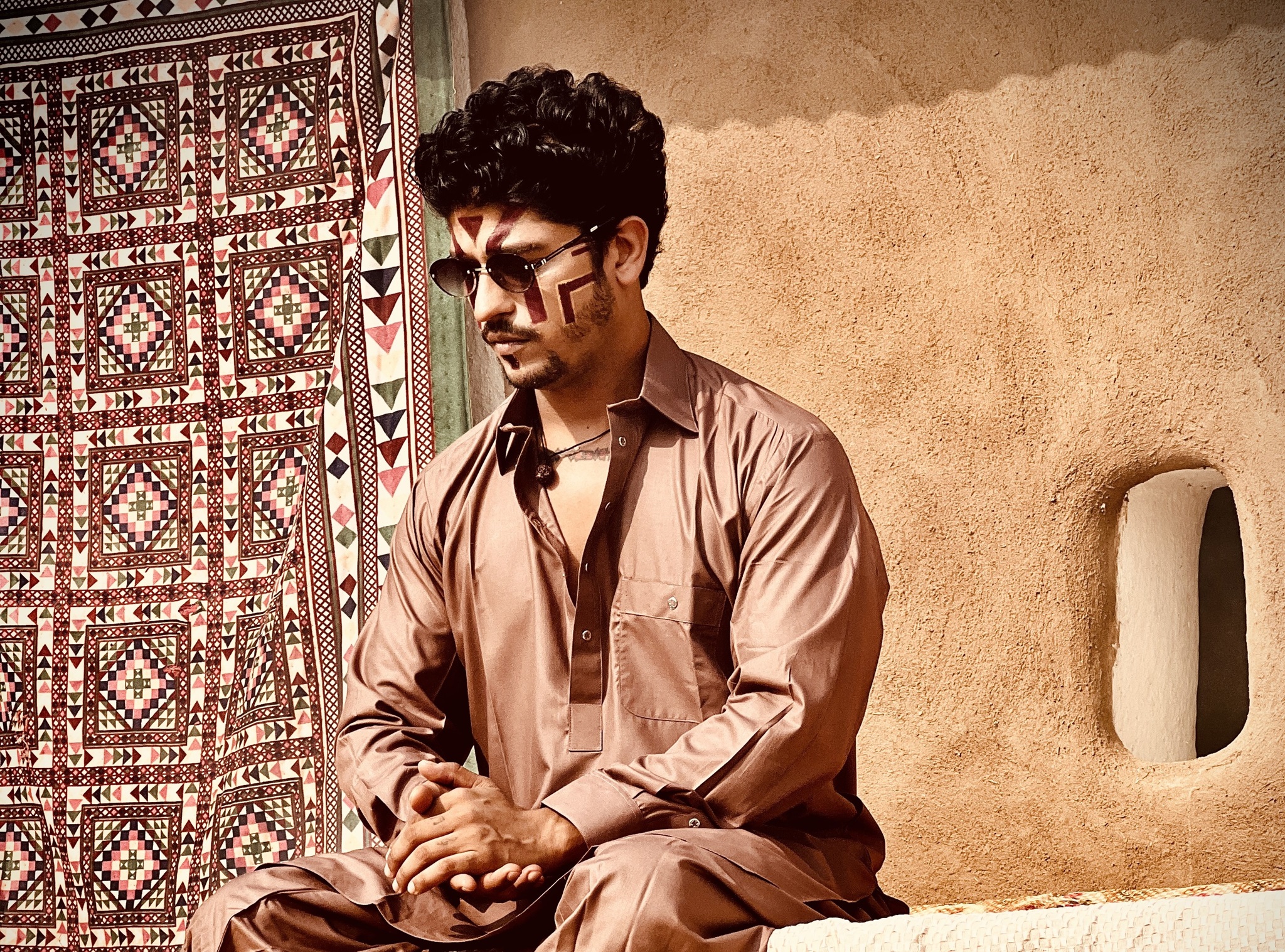 Indie artist Prateek Gandhi wearing sunglasses, with face painted and wearing brown kurta