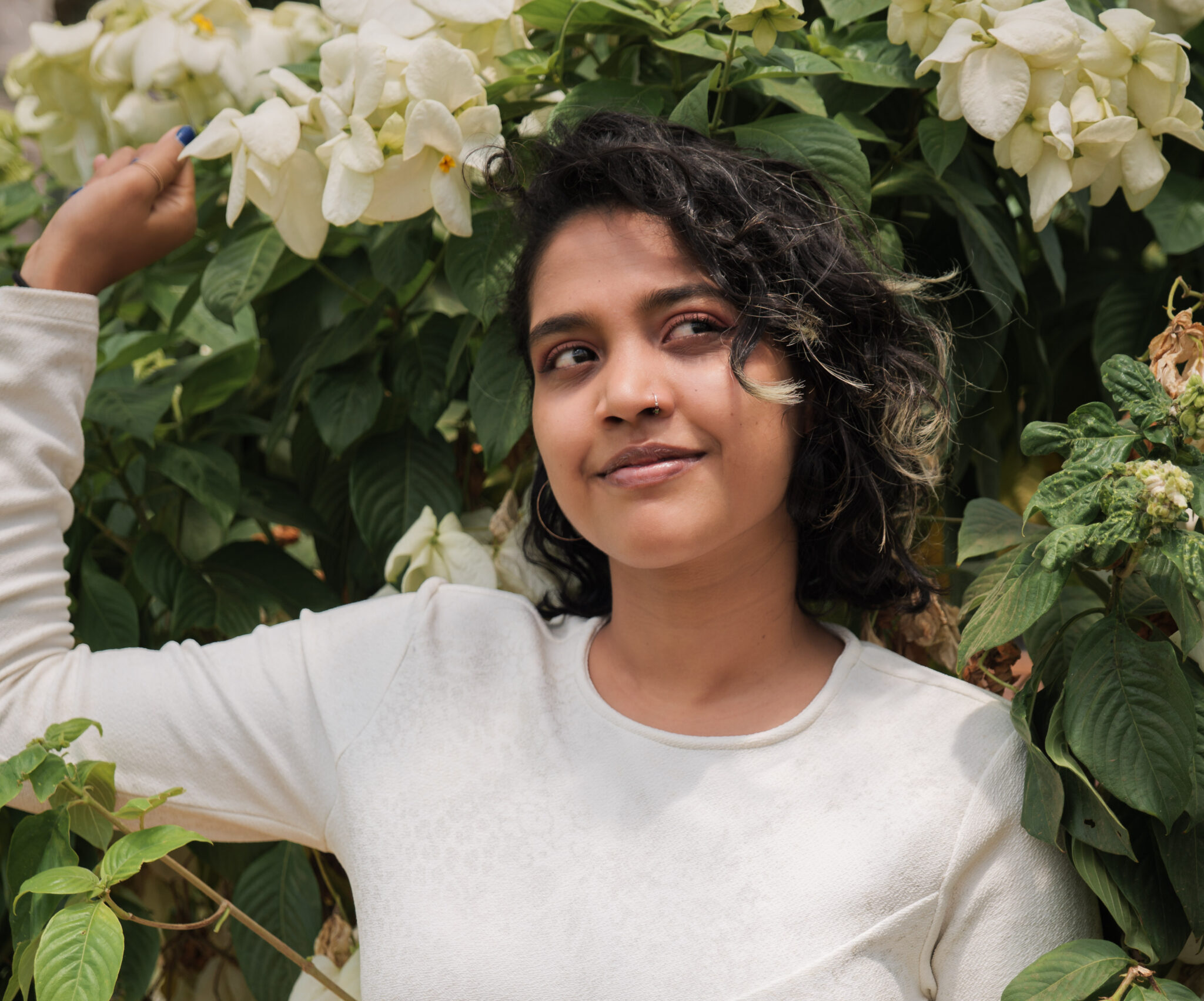 Brecilla wearing a white top smiling with flowers in the background