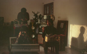 Members of indie band Green Park pose for a photo in a living room with instruments