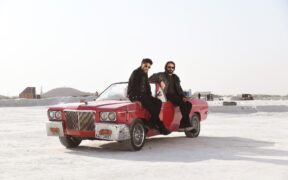 Guru Randhawa and Babbu Maan sitting on a red convertible car in the Pagal music video