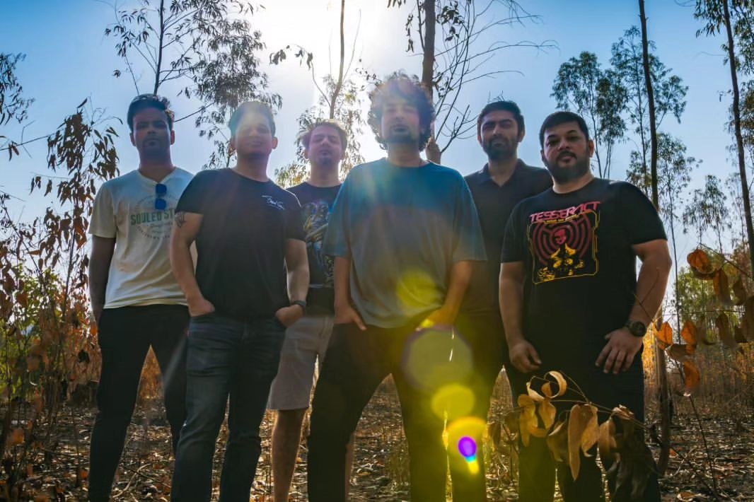 The Pulse Theory band members posing outdoors amid greenery and sunlight