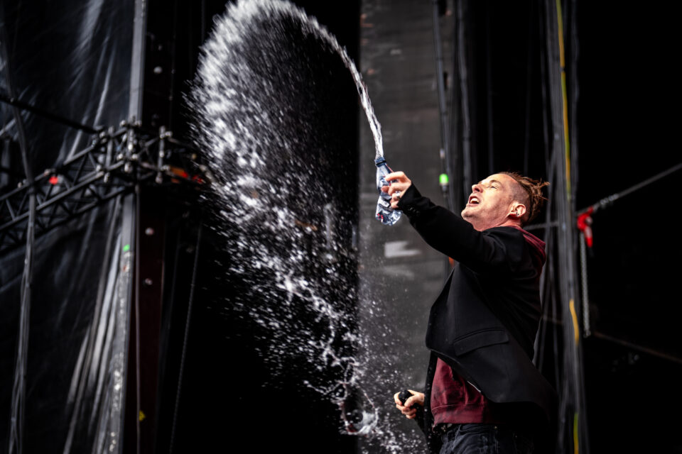 Corey Taylor splashes water from his bottle on stage