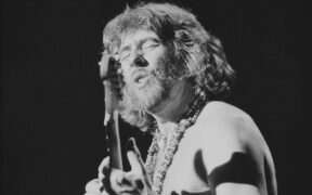 John Mayall playing guitar on stage