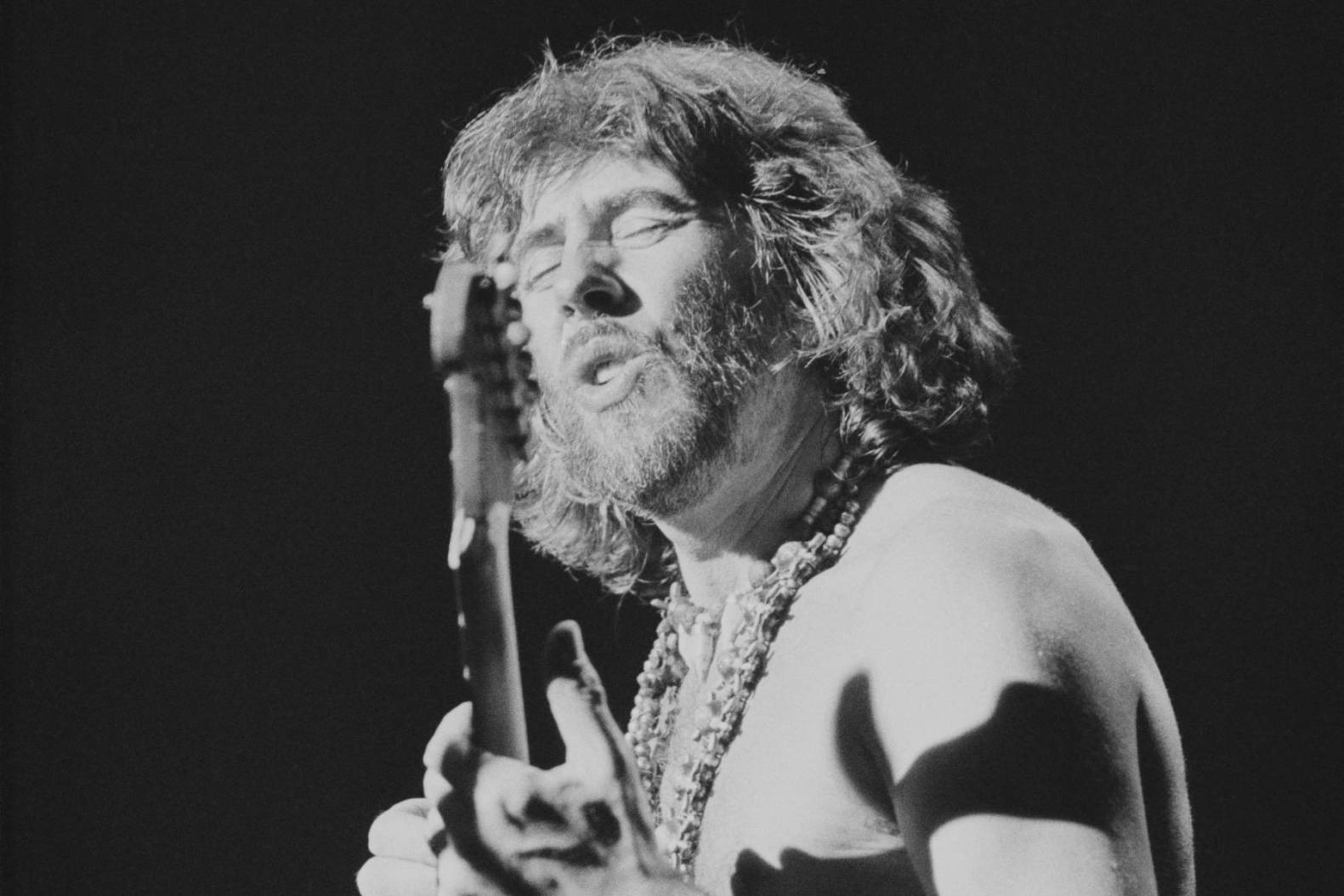 John Mayall playing guitar on stage