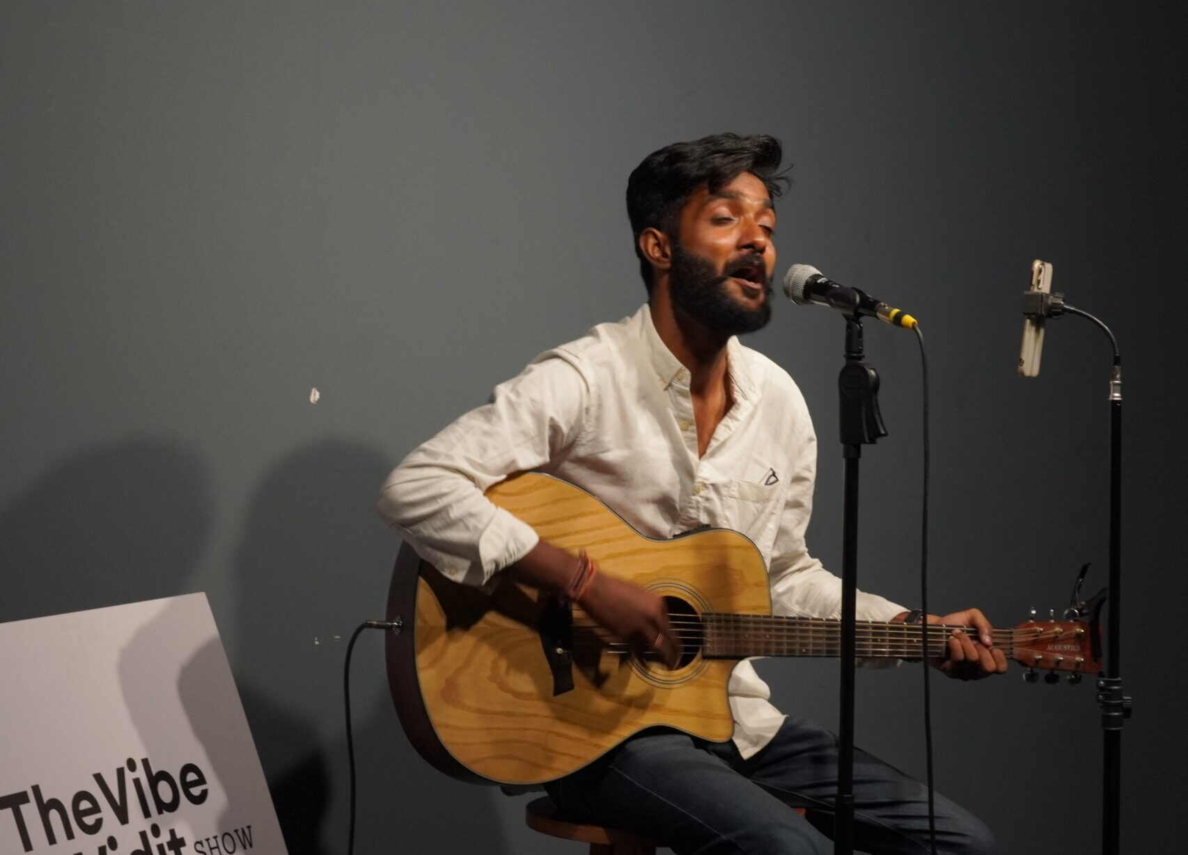 Vidit Meghwal in white shirt and jeans singing with guitar