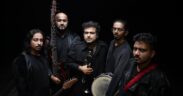 Band members of Daira posing with instruments, wearing black