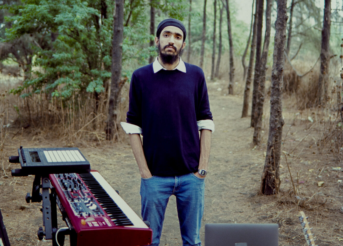 Sudan standing around trees with synthesizer and computer