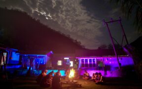 Musicians jamming by a bonfire under a night sky