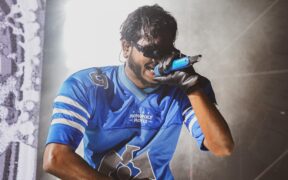 King wearing blue jersey singing on stage