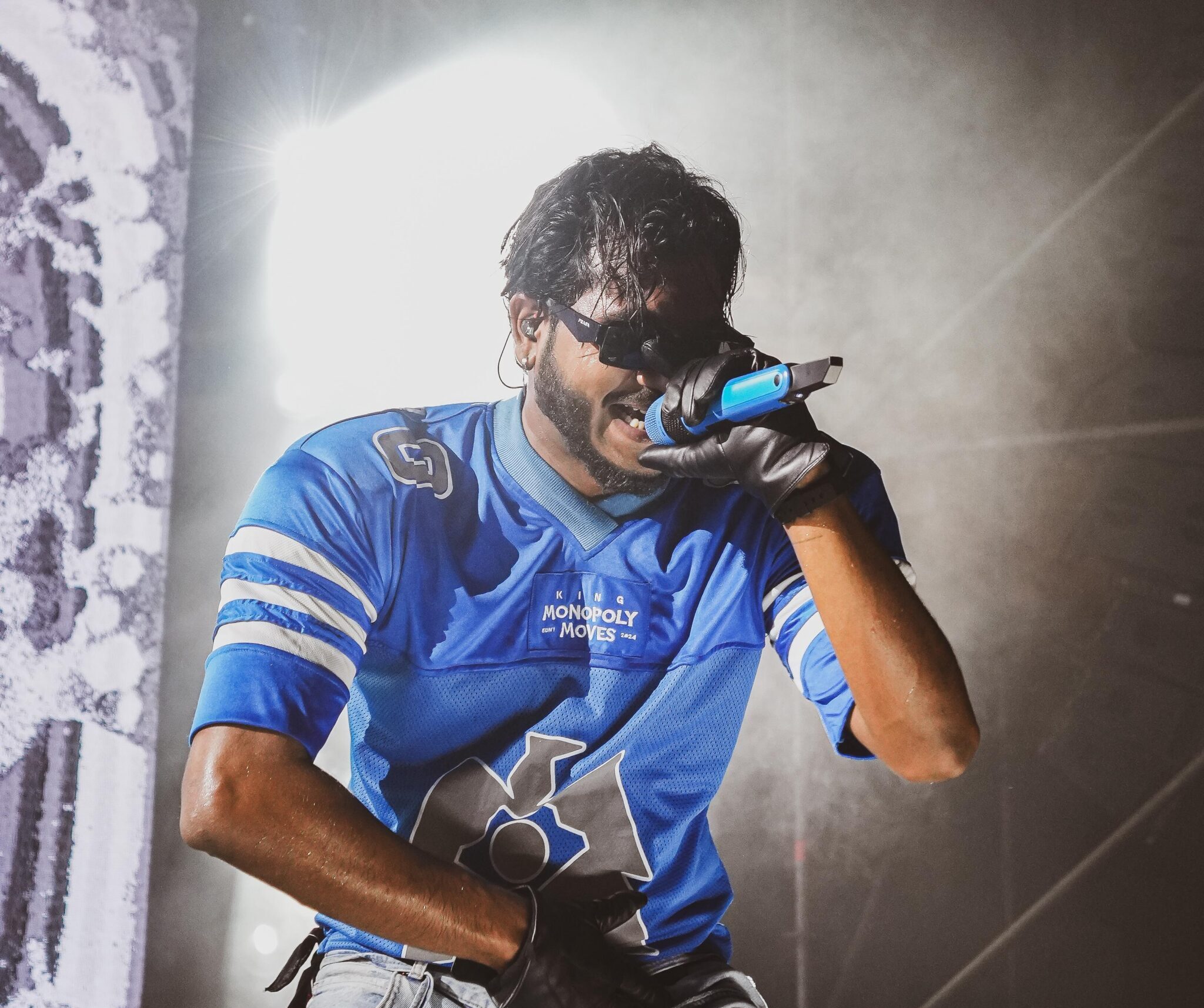 King wearing blue jersey singing on stage