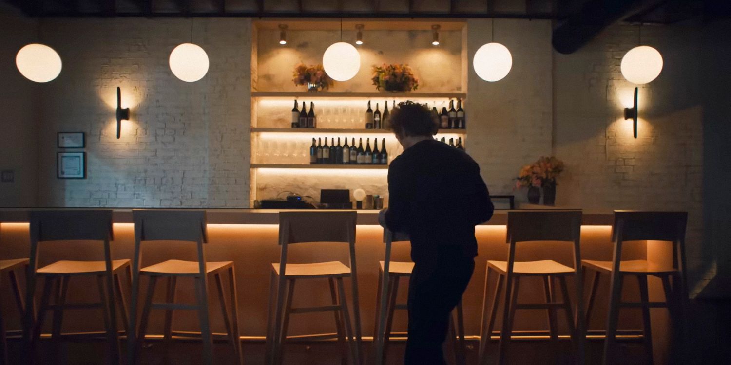 Chef Carmy walking into a table area of a restaurant in a still from the series 'The Bear'