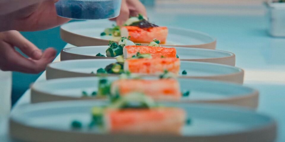 Plates of food lined up on a kitchen table 