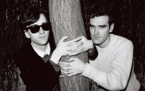 Johnny Marr and Morrissey of the group The Smiths posed with their arms around a tree trunk in London in 1983