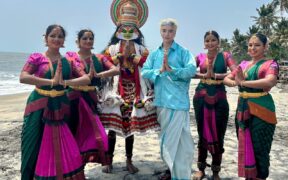 Aoora, the K-pop artist in a blue shirt and mundu with Mohiniyattam and Kathakali dancers